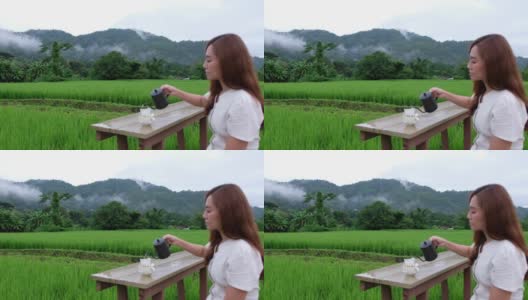 模糊的一个女人在稻田滴咖啡与美丽的自然景色高清在线视频素材下载