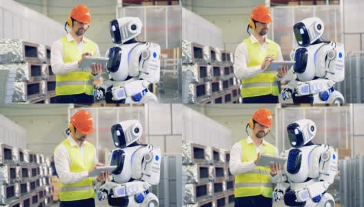 男性工人与机器人交谈，在平板电脑上向机器人显示信息，然后在机器人的显示器上输入信息。4 k。高清在线视频素材下载