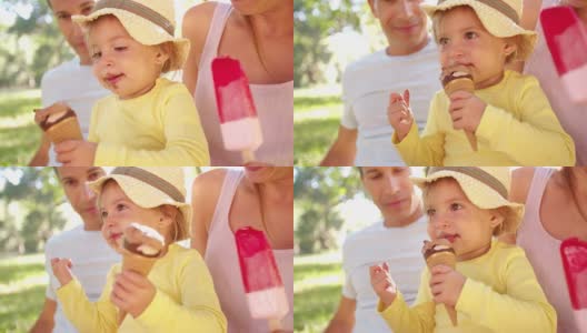 一家人和女儿在公园里愉快地吃冰淇淋高清在线视频素材下载