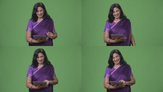 成熟快乐美丽的印度女人微笑着使用数字平板电脑高清在线视频素材下载