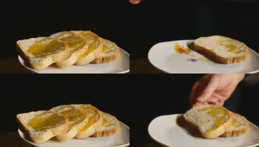 黑色背景下流淌着蜂蜜的一片片烤面包高清在线视频素材下载