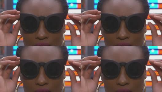 年轻的非洲裔美国女性戴着太阳镜在时代广场的美国国旗前自拍高清在线视频素材下载