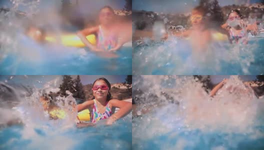男孩和女孩在游泳池里玩溅水高清在线视频素材下载