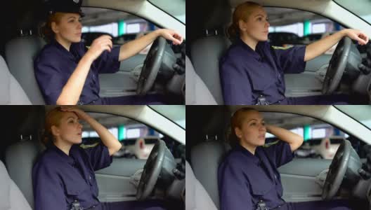 疲惫的女警察脱下警帽坐在巡逻车里，上夜班高清在线视频素材下载