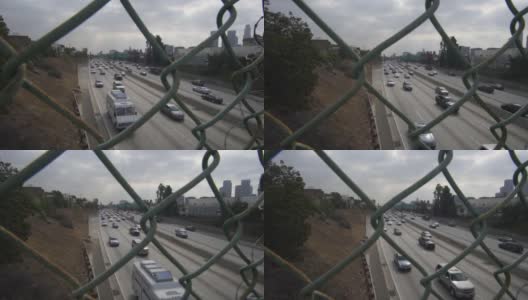 在多云的日子里，通过慢动作的链链围栏在洛杉矶繁忙的高速公路交通的观点高清在线视频素材下载