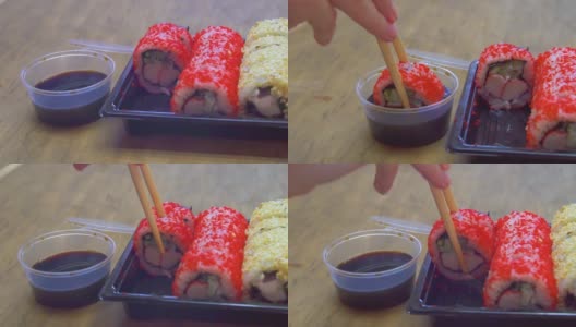 特写镜头。有人用筷子、卷和酱油吃寿司高清在线视频素材下载