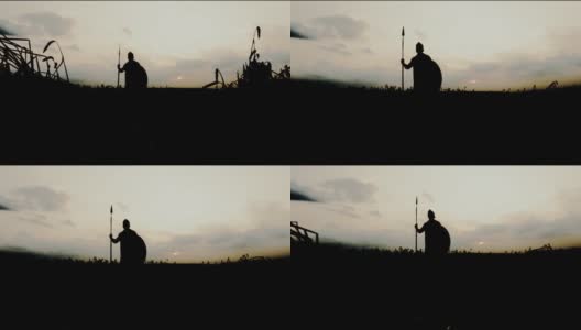 在干燥的田野里，战士手持长矛摆姿势的剪影。高清在线视频素材下载
