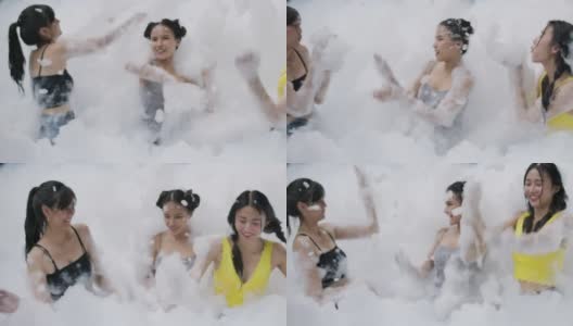 年轻女子在泳池里玩泡沫和泡泡的肖像。高清在线视频素材下载