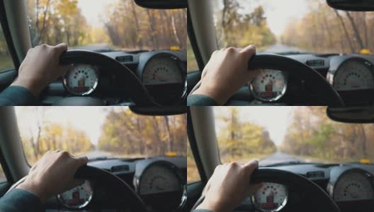 一个男人的手在方向盘上，在一个秋天的一天驾驶汽车。第一人称视角高清在线视频素材下载