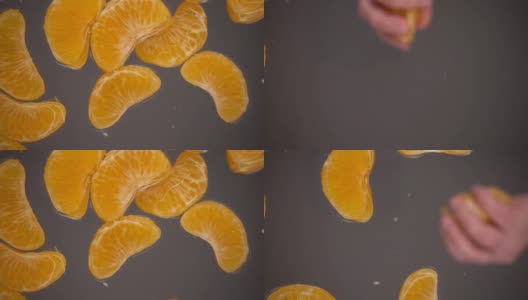 去皮的橘子片落入玻璃表面的水中。底部视图。缓慢的运动。高清在线视频素材下载