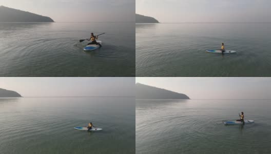 鸟瞰图的早晨瑜伽练习与柔和的阳光在海上。高清在线视频素材下载