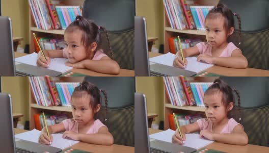 可爱的小女孩在家在线学习数学作业，在冠状病毒爆发期间保持社交距离。网络教育或家庭教育的概念。高清在线视频素材下载