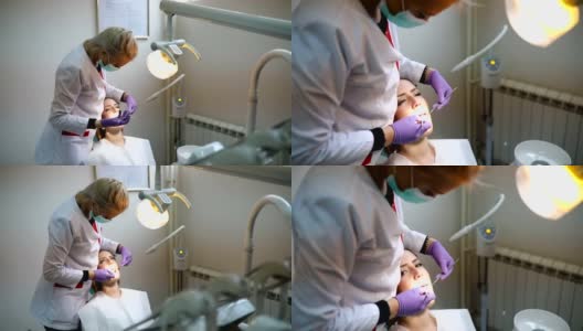 在牙科诊所接受牙科治疗的美女病人。看牙医的女人高清在线视频素材下载