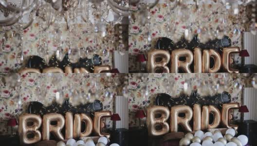 用金色的氦气球包裹上“新娘”字样。新娘早晨，气球上的“新娘”一词被放在卧室里。单词“bride”的字母。垂直平移镜头高清在线视频素材下载