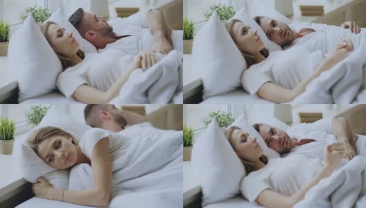 这是一对关系有问题的夫妇躺在家里的床上进行情感对话的特写。年轻女子拒绝了她的男朋友高清在线视频素材下载