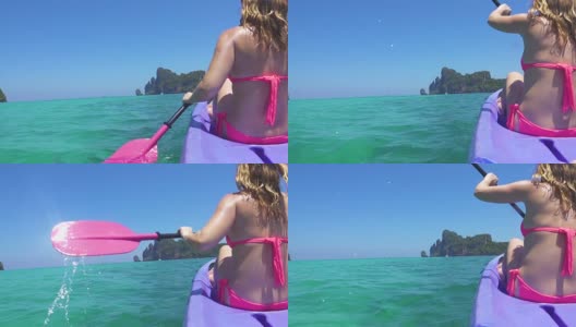 慢动作:在平静的绿松石海水中，一名辨认不出的女性游客划着皮划艇。高清在线视频素材下载