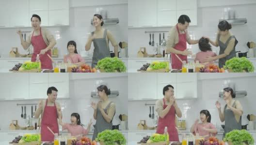 快乐快乐的亚洲家庭一起跳舞，在厨房做饭。高清在线视频素材下载