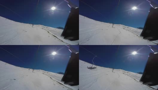 从上到下的雪坡，痕迹，滑雪者和降落伞从椅子升降机。第一人称视角高清在线视频素材下载