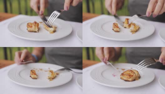 特写镜头——一个身份不明的女人用餐刀切羊角面包高清在线视频素材下载
