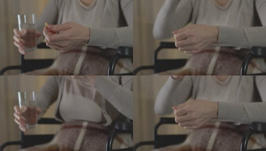 成熟的女人坐在轮椅上吃风湿药，双腿无力高清在线视频素材下载