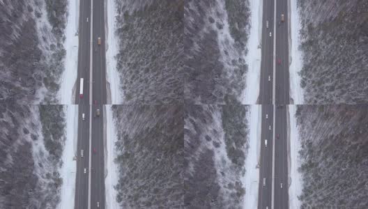 空中景观车在冬季高速公路上通过积雪的森林高清在线视频素材下载
