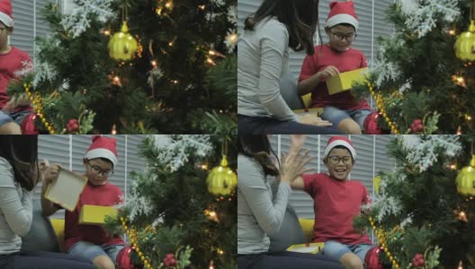兴奋的圣诞男孩打开惊喜的礼物，一脸的惊讶和震惊。快乐的孩子与礼物。家庭生日聚会。香港圣诞节高清在线视频素材下载