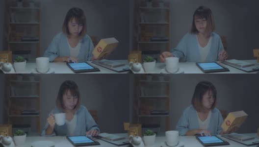 亚洲年轻的女企业家企业主中小企业在线检查产品库存，保存到平板电脑和喝咖啡在家里工作到深夜。小企业主在家办公的概念。高清在线视频素材下载