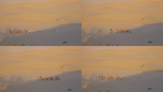美丽的黄昏景观的沙漠和骑骆驼的人在甘肃敦煌中国。高清在线视频素材下载