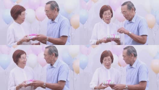 亚洲老夫妇拿着礼物在家庆祝生日。老年人在家里一起享受快乐时光。老年人家庭在家的概念。高清在线视频素材下载
