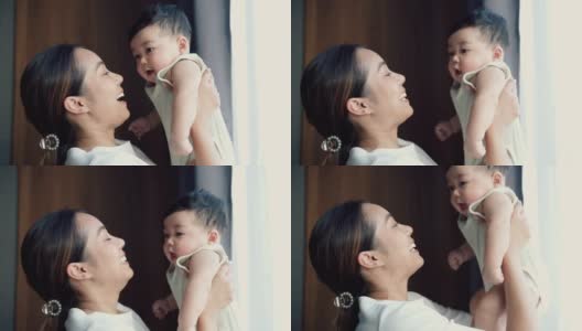 年轻的亚洲母亲抱着她可爱的儿子高清在线视频素材下载
