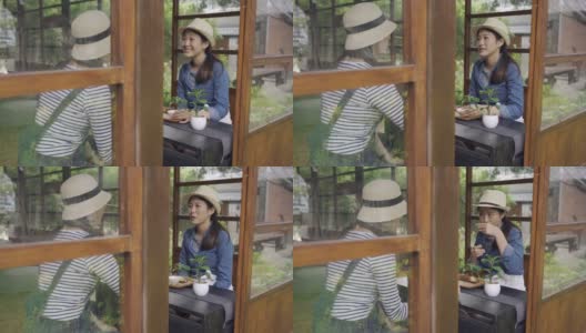 两个微笑的亚洲女性朋友在日本京都旅行，体验日本文化的秋道仪式。年轻的女孩游客聊天，喝茶，戴着草帽，坐在木桌旁边高清在线视频素材下载
