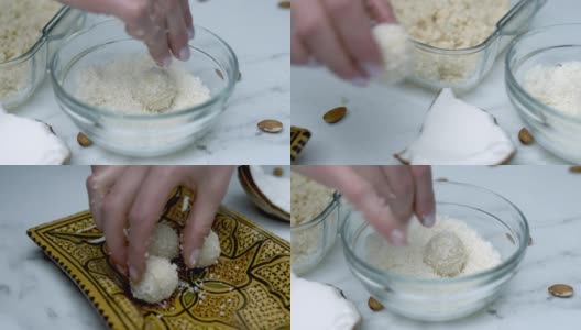 特写:将白巧克力碗浸入/混合在一个玻璃碗里的干椰子里，然后将它们放入一个盘子里。准备自制椰子巧克力的概念。高清在线视频素材下载