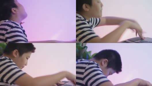 快乐的亚洲男孩在家里和家人玩电子键盘，生活方式的概念。高清在线视频素材下载