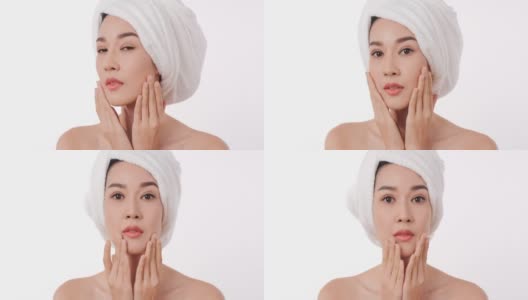亚洲美丽的女人检查她的脸在白色的背景。高清在线视频素材下载