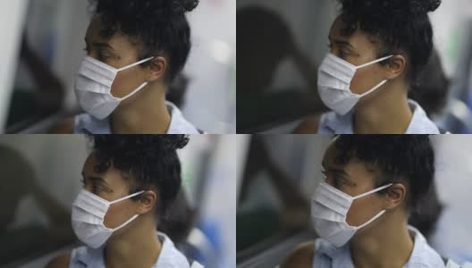 年轻女子戴着医用口罩乘坐地铁。乘地铁上下班的学生或工人望着窗外高清在线视频素材下载