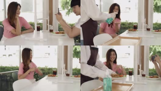 4K超高清多莉拍摄:亚洲美女女招待上菜，并在用餐前将酒精洗手液推送给顾客，以减少被冠状病毒感染的机会。新常态卫生生活理念。高清在线视频素材下载