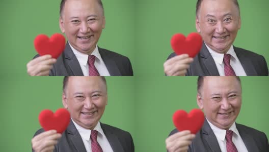成熟的日本商人手捧红心准备过情人节高清在线视频素材下载