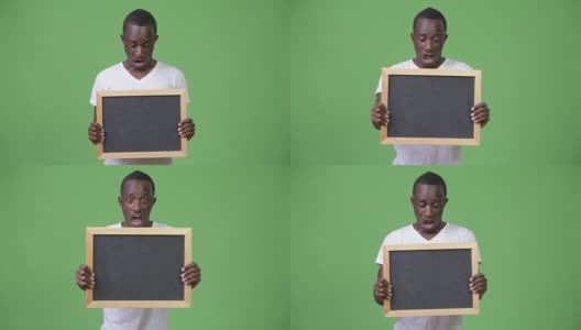 年轻的非洲人展示黑板，看起来很震惊高清在线视频素材下载