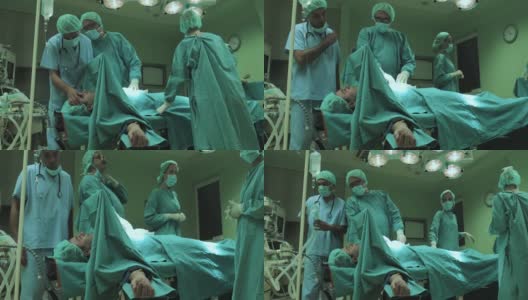 一组医学专家在手术室完成了手术，并开始唤醒病人。高清在线视频素材下载