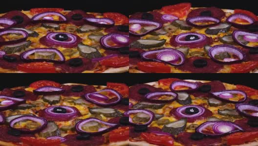 美味的自制披萨，配上泡菜、意大利腊肠、番茄、橄榄、奶酪和洋葱圈高清在线视频素材下载