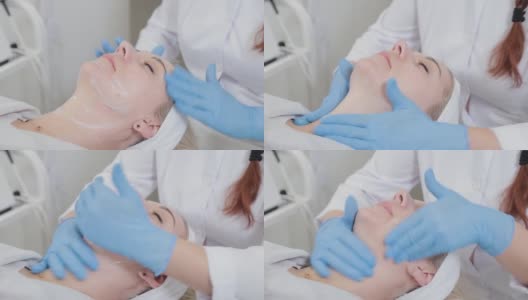 在美容诊所里，专业的美容师给一个女人按摩脸部高清在线视频素材下载