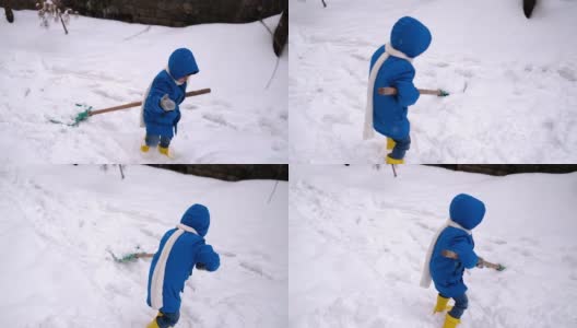 小男孩在冬天铲雪。高清在线视频素材下载