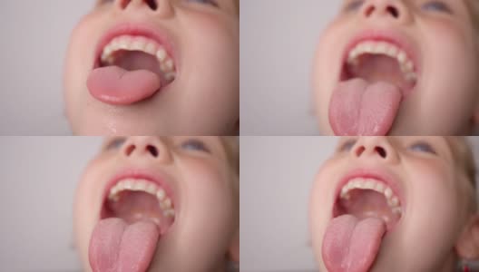 女孩张大嘴巴，伸出长长的舌头。孩子露出了他的牙齿高清在线视频素材下载