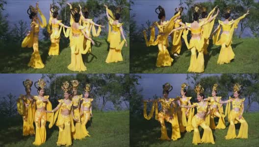 五名亚洲女演员穿着中国传统的黄色服装在河边跳着美丽的舞蹈高清在线视频素材下载