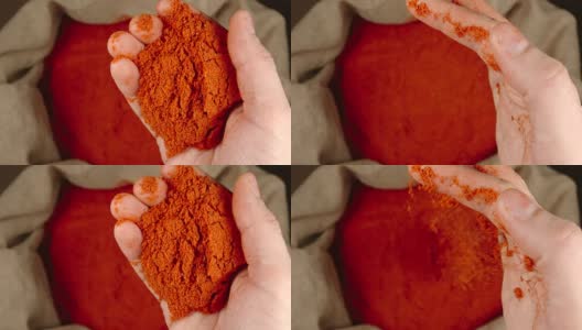 俯视图:人的手拿着一把红辣椒粉放在一个袋子上，然后把它扔出去——慢镜头高清在线视频素材下载