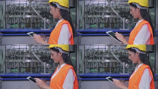 在工厂工作的女工业工程师。年轻漂亮的中国工程师在大型工厂工作。戴安全帽，穿安全服。以高科技自动化机器为背景。高清在线视频素材下载