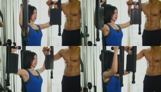 年轻的健身女士在健身房用负重器械做运动，健身训练理念高清在线视频素材下载