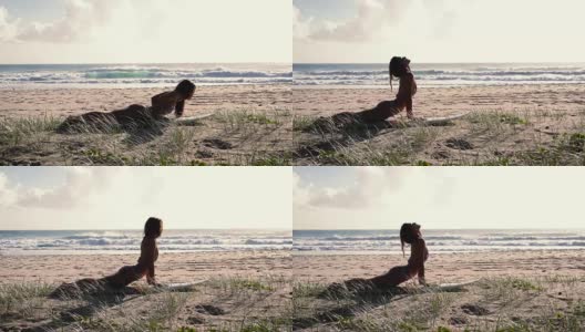 健康女孩伸展在冲浪板上在日出的海滩上。幻灯片。缓慢的运动。高清在线视频素材下载