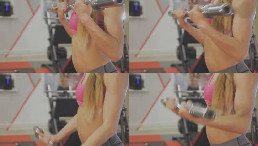 女人在健身房的一个酒吧里训练。漂亮的身体高清在线视频素材下载