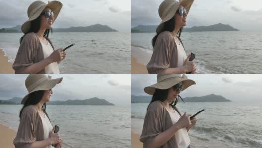 亚洲女游客在海滩上使用手机高清在线视频素材下载